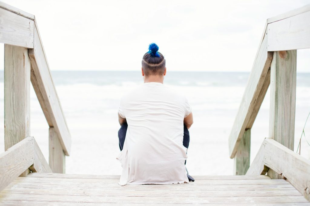 man sitting on wooden staircase